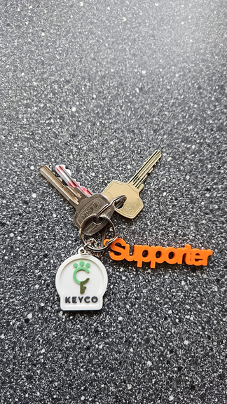Close-up van oranje Supporter-hanger en Keyco-sleutelhanger